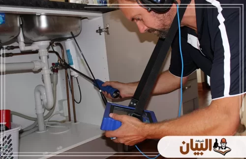فني يفحص تمديدات أسفل الحوض بأجهزة إلكترونية للوصول إلى مصدر التسرب.